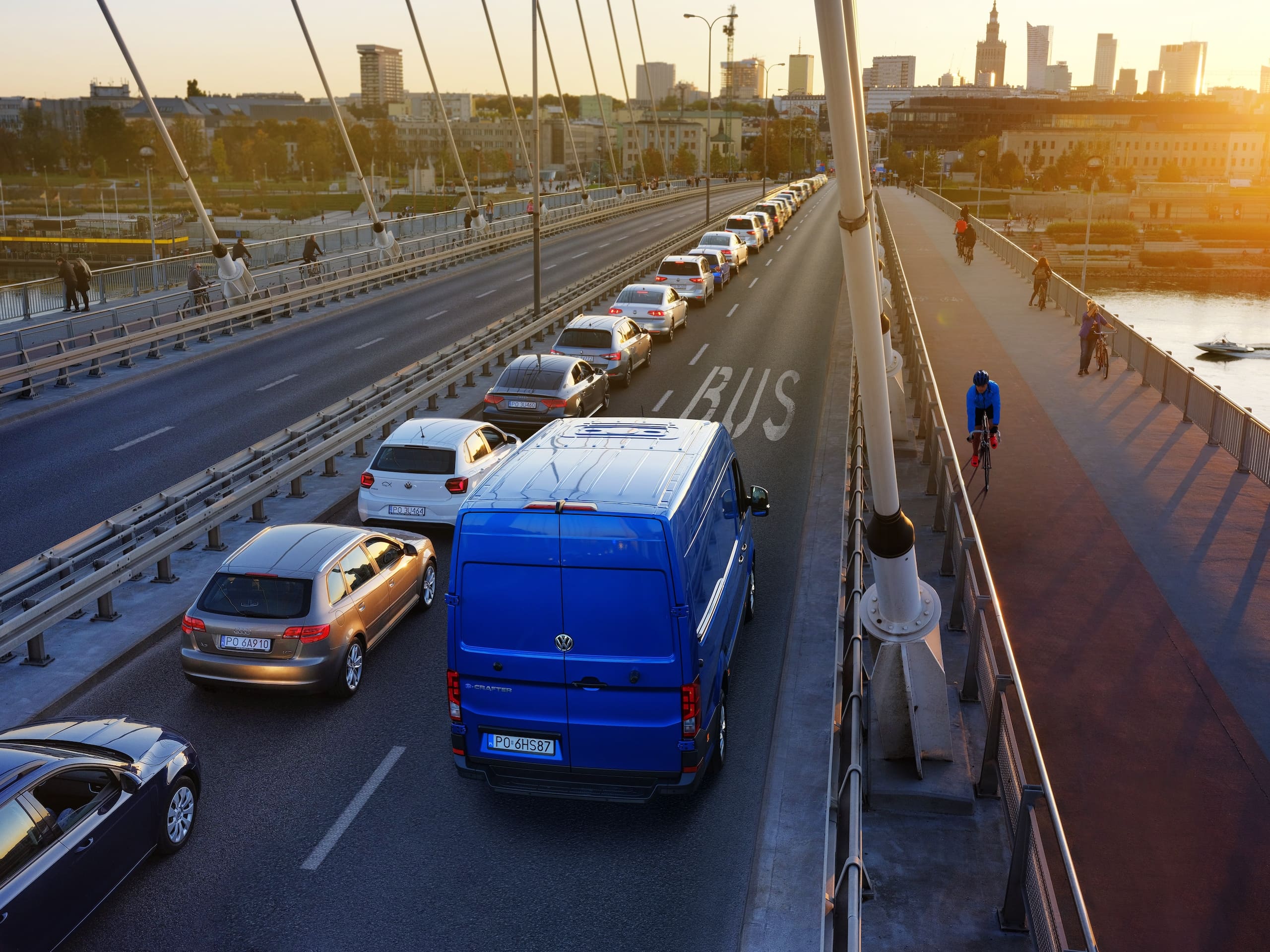 Niebieski Volkswagen e-Crafter z wysokim dachem przejeżdża most buspasem.